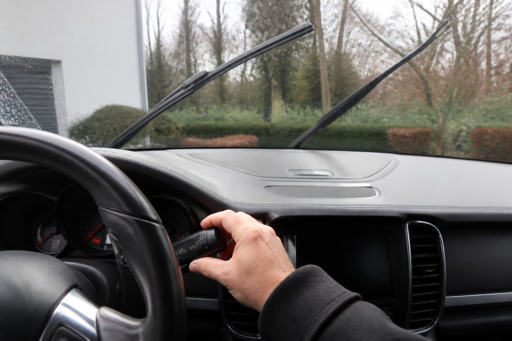 Driver pulling the wiper stalk to activate the service position on the windshield