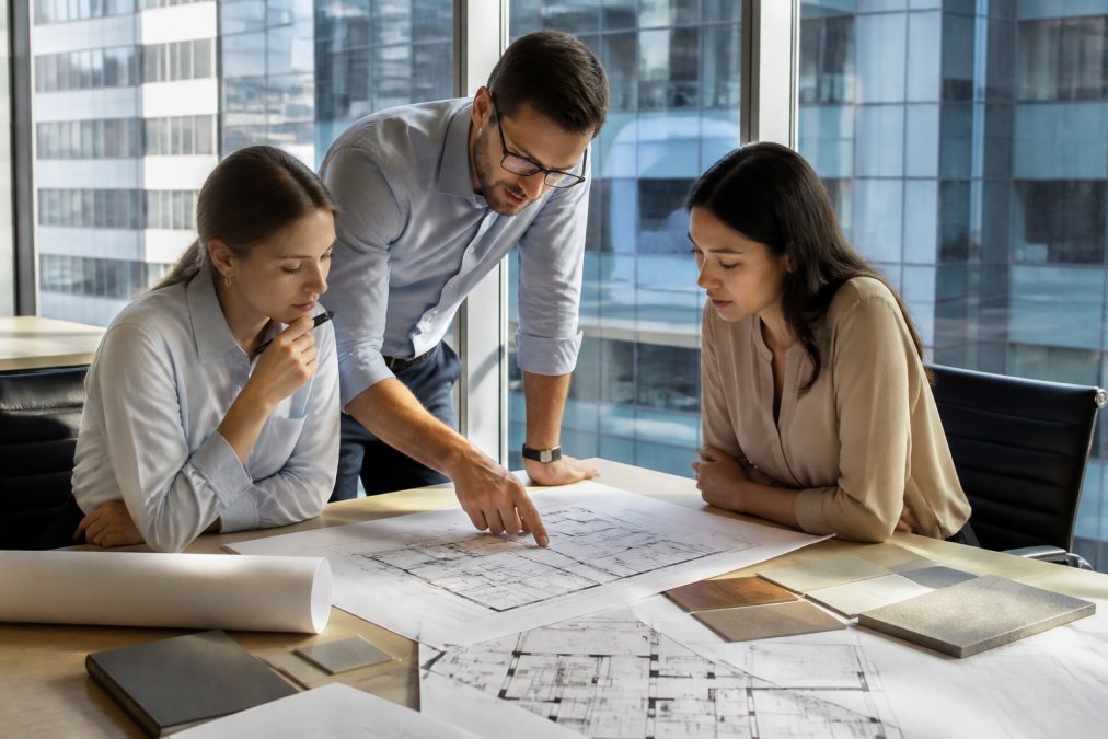 Team reviewing a floor plan layout to scale office space based on how their specific workflow functions.