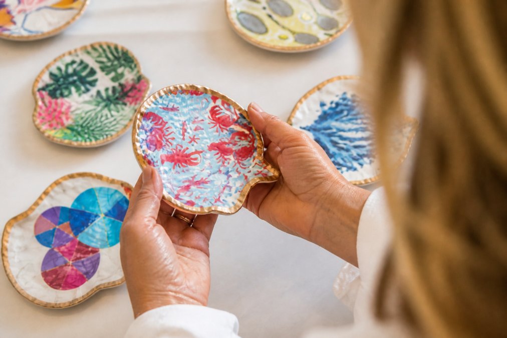 Close-up of artisan hands examining handcrafted ceramic vessel details, natural studio lighting showing texture and glaze quality