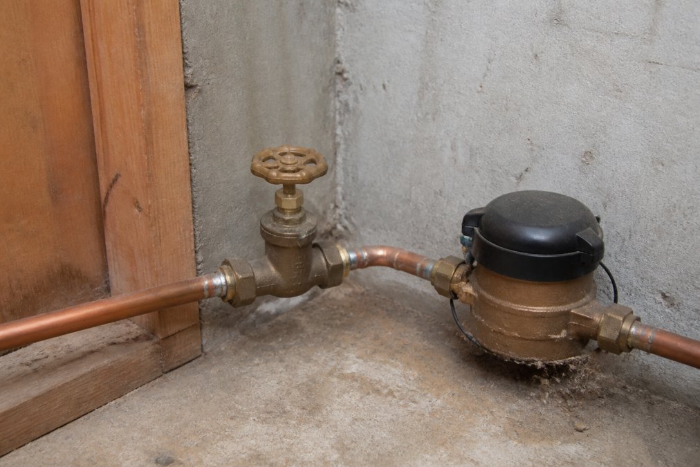 Diagram showing the location of a basement main water shutoff valve near the water meter and copper piping.