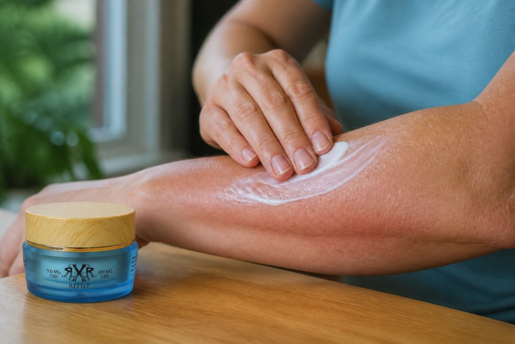 Close-up of hands applying thick, creamy moisturizer lotion to the forearm, showing the product being smoothly absorbed into the skin with a glossy finish, natural daylight from a window