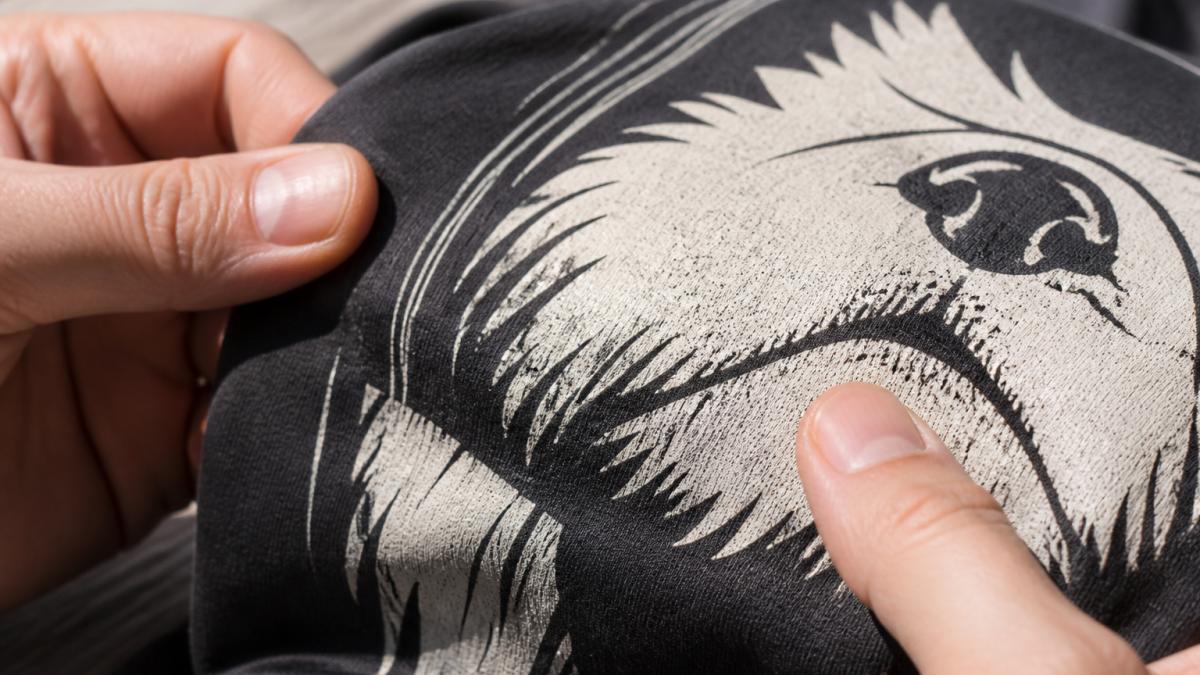 Diagram illustrating steps to inspect screen-printed texture and fabric weave on a graphic t-shirt.