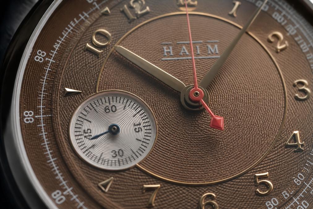 Macro photography of a watch dial showing intricate guilloche pattern with applied numerals and indices, light reflecting off the textured surface revealing depth and precision