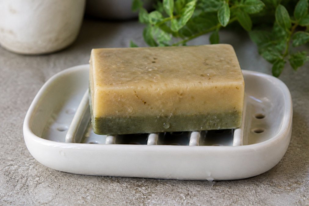 Diagram showing how a ceramic dish with drainage slats helps stop soap from dissolving by promoting airflow.