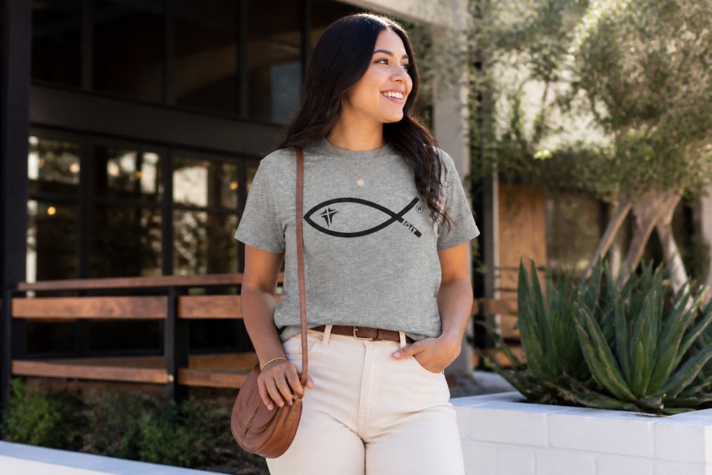 Person wearing a scripture-based graphic tee styled with neutral earth tones, a crossbody bag, and minimal accessories for a casual chic look suitable for everyday wear