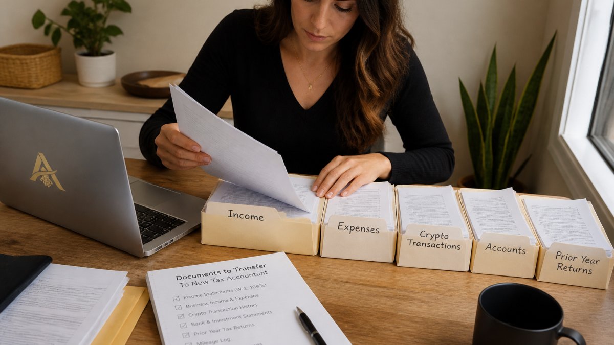 A person at a tidy desk organizing tax documents into labeled folders beside a laptop, with a printed checklist and a pen on the table