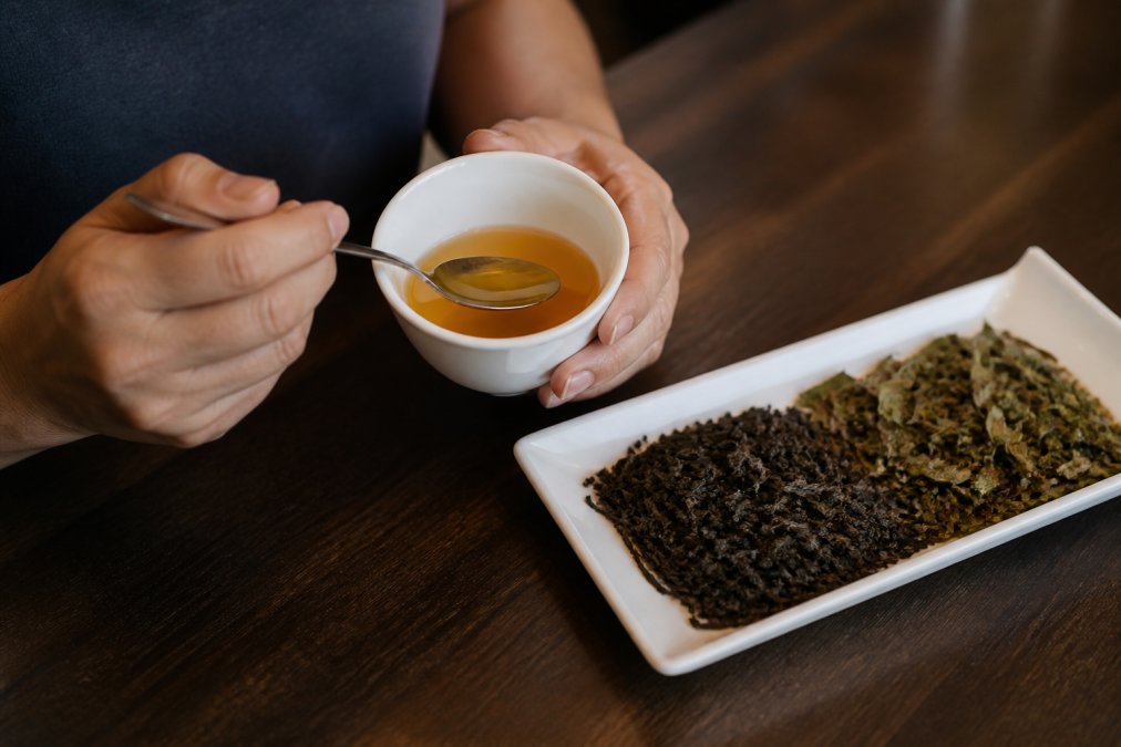 Infographic illustrating the step to taste tea by aerating and evaluating the amber liquor and tea leaves.