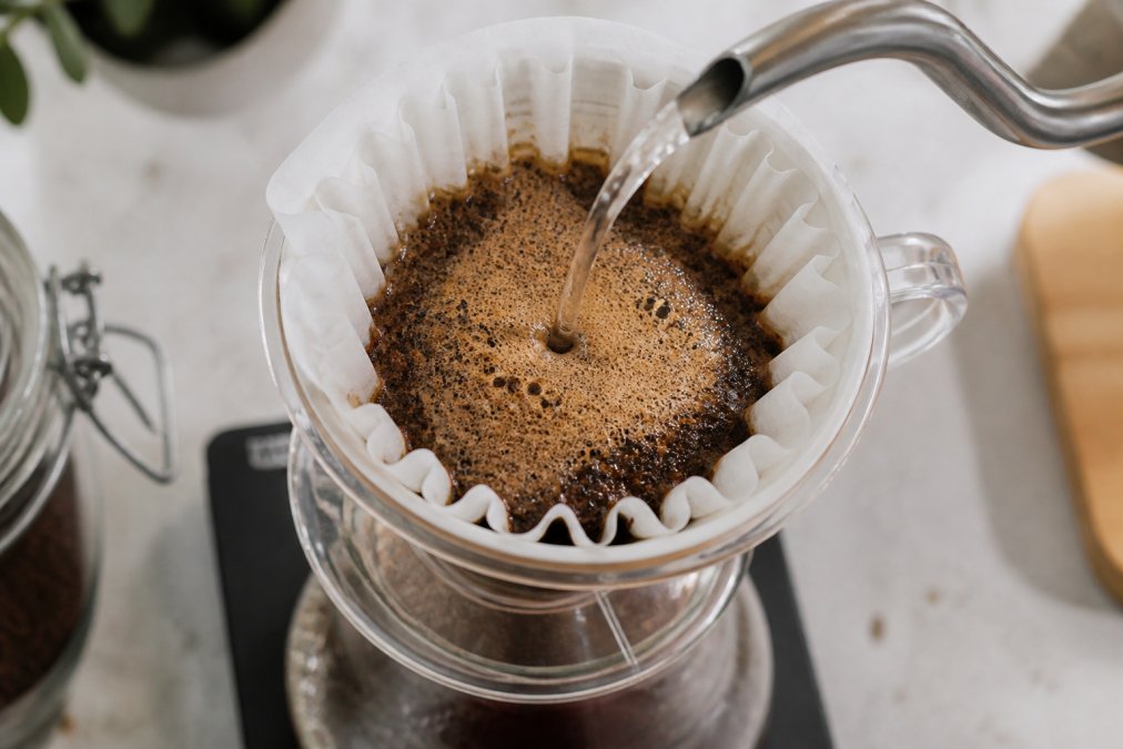 Diagram showing how to tell if coffee beans are fresh by observing the bubbling bloom of grounds during a pour-over.