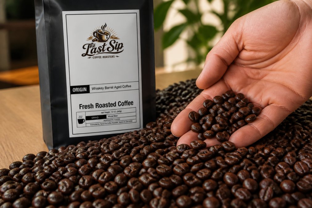 Close-up of fresh coffee beans showing glossy shine and even coloring, with a hand holding a few beans to display texture and sheen