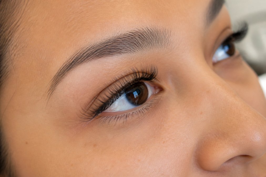 Close-up of perfectly isolated and uniform lash extensions with precise application on a client’s eye.