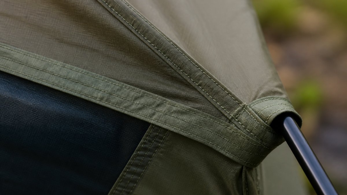 Close-up of reinforced tent seam showing tight, even stitching with reinforced edges on authentic camping equipment