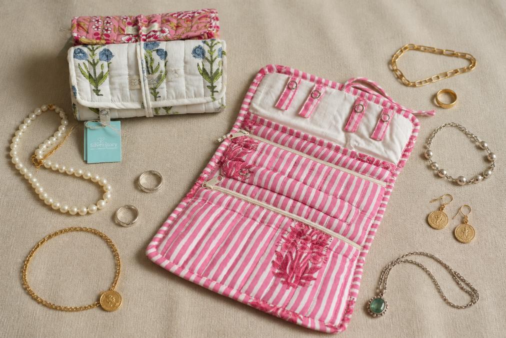 A collection of vintage and contemporary jewelry pieces displayed on a neutral fabric surface, showing variety of styles and ages