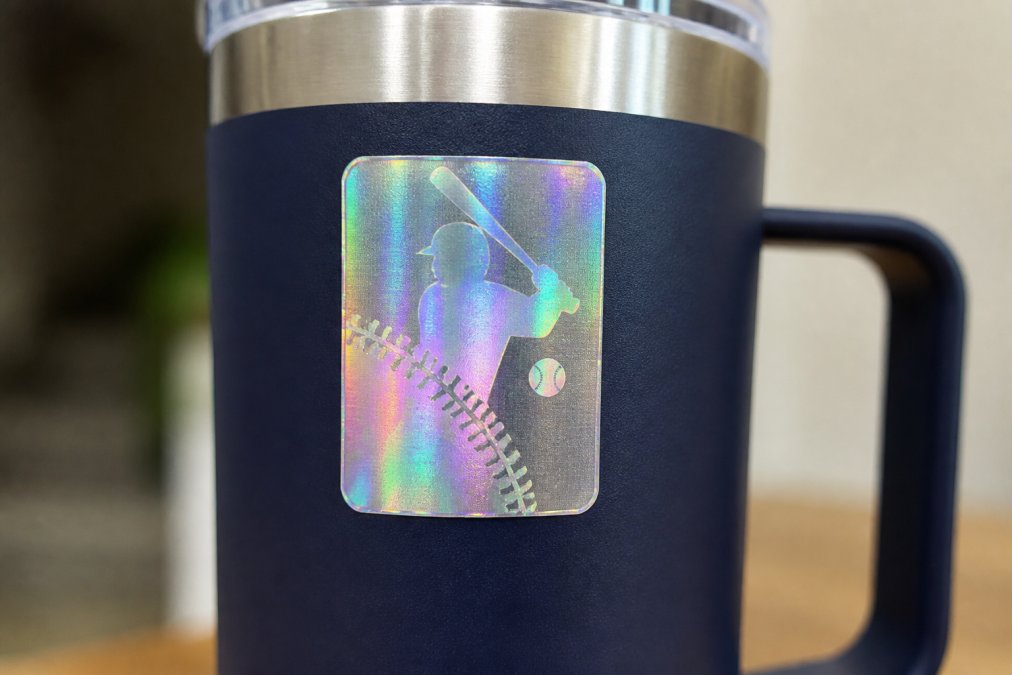Close-up of authentic holographic security label on sports apparel showing iridescent color-shifting details, light refraction patterns, and three-dimensional depth effects under natural lighting