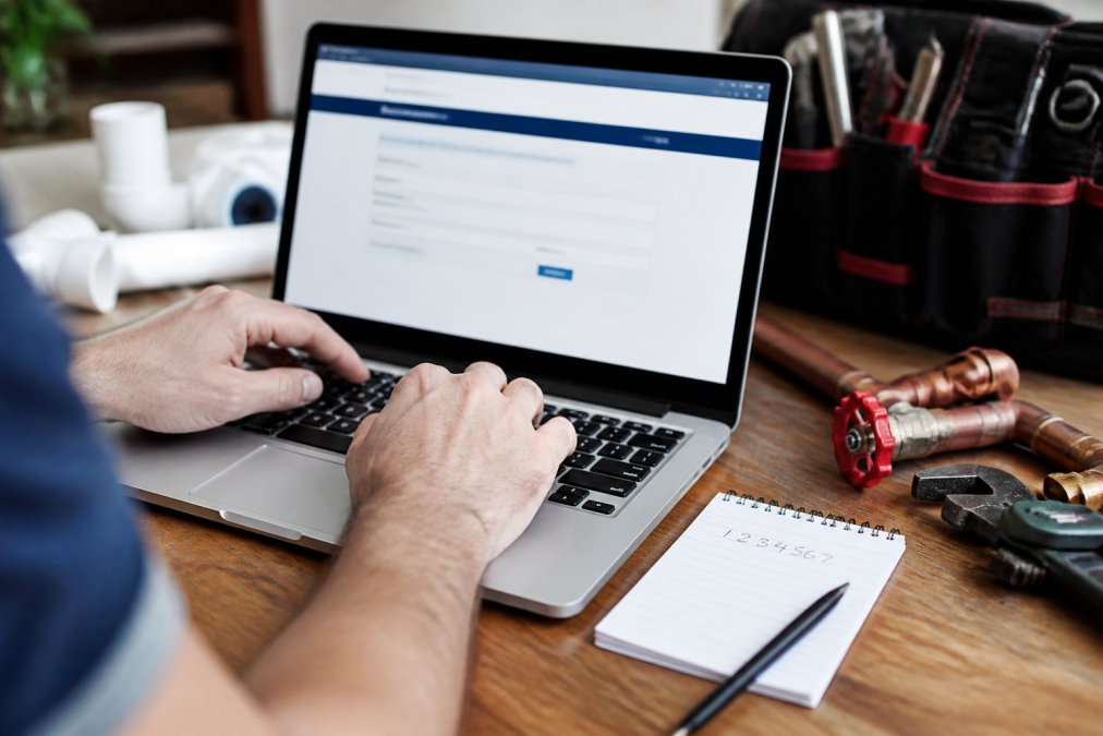 Homeowner using a laptop to verify plumbing company license details online