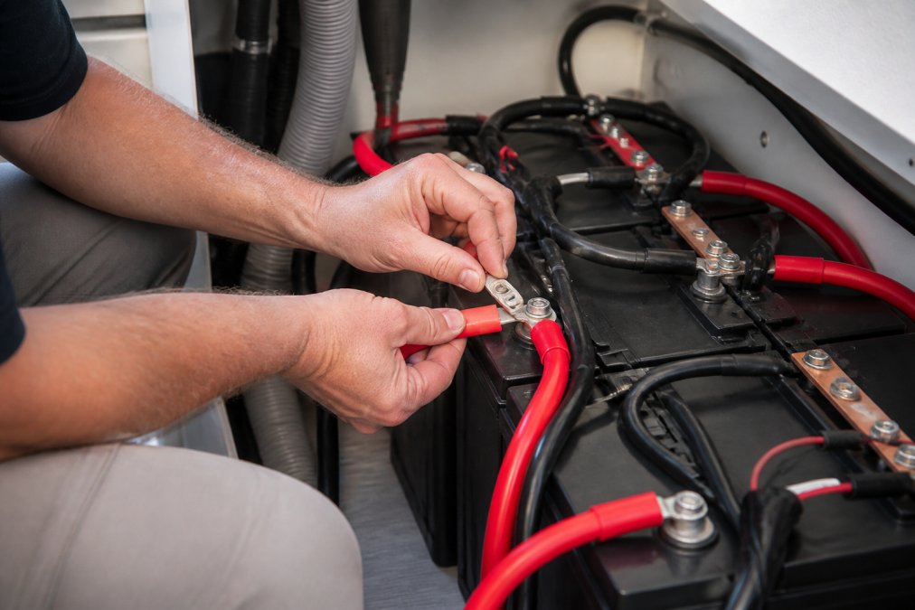 Step-by-step diagram showing how to wire lithium batteries RV style using busbars and color-coded cables.