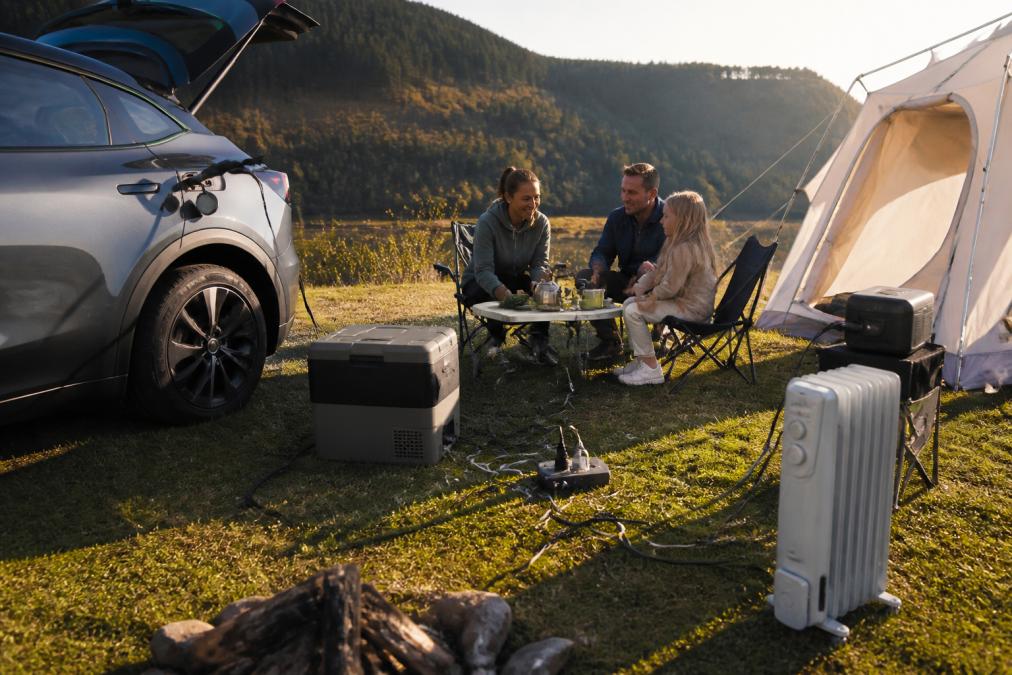 Family camping with electrical appliances connected to an electric car via V2L, so you can see which appliances the electric car V2L can power.