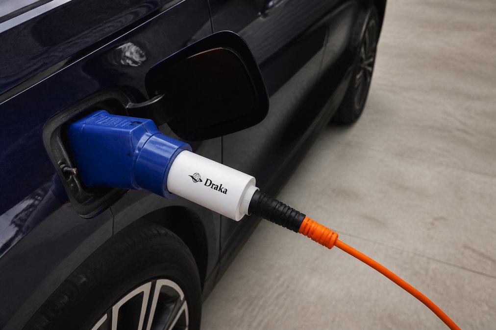 Sertifikuoto V2L adapterio, prijungto prie elektromobilio 2 tipo įkrovimo prievado su pritvirtintu standartiniu buitiniu ilgintuvu, stambus planas, rodantis tinkamą prijungimo sąranką.