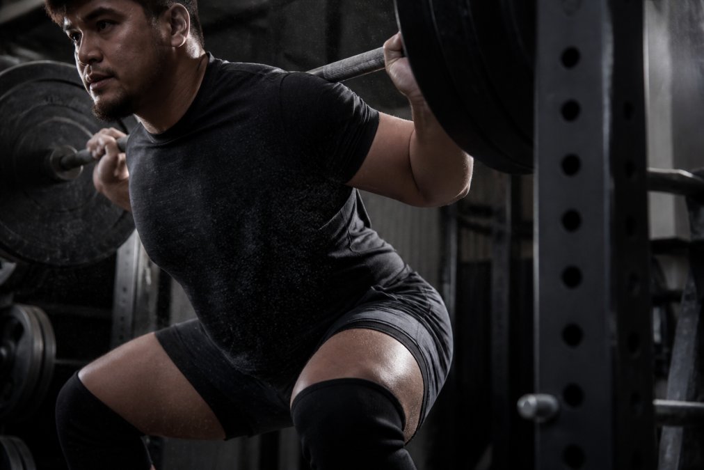 Powerlifter performing a heavy barbell squat wearing a durable hylete alternative short with four-way stretch fabric.