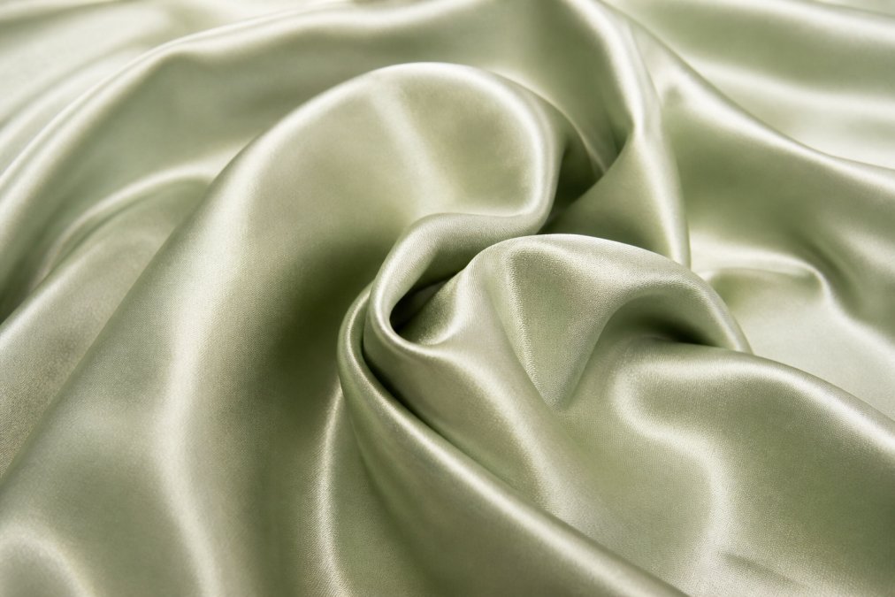 Close-up of luxurious bamboo viscose fabric texture with natural soft lighting highlighting the smooth, silky weave and lustrous sheen of the material