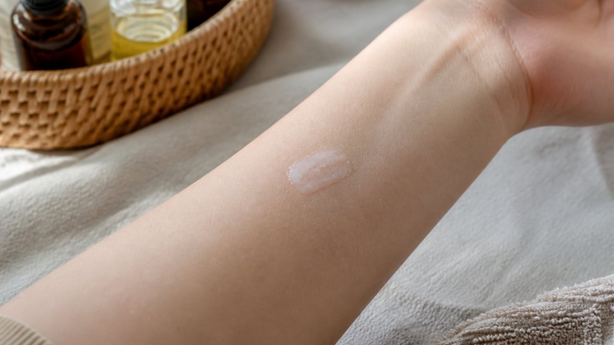 Step-by-step diagram illustrating how to patch test skincare products on the inner forearm for eczema safety.