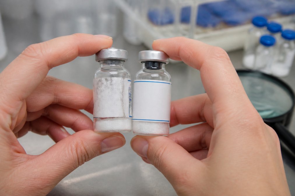 Hands comparing a smudged vial to a professional one for identifying fake research peptide suppliers
