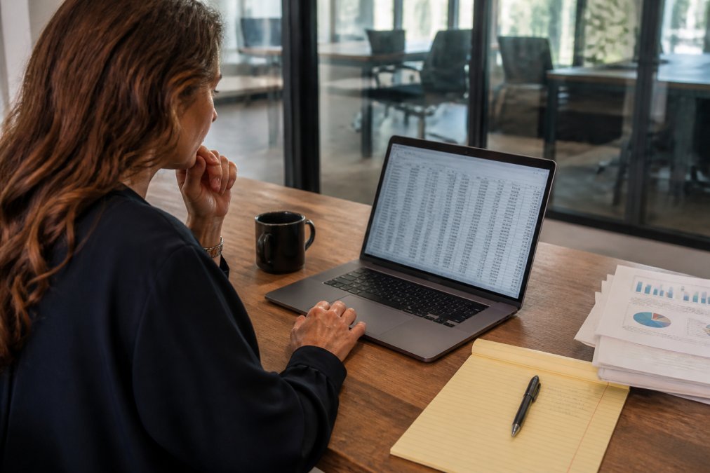Business professional auditing CRM records to help with implementing ai sales without messy data in a modern office.