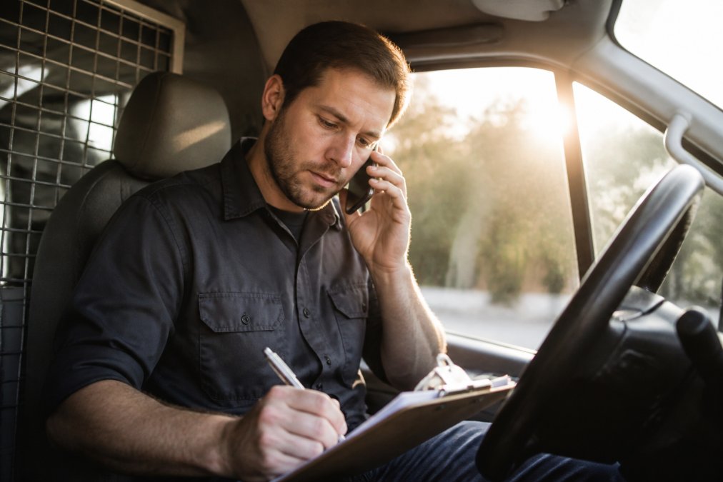Trades professional taking notes on a customer inquiry in a truck to improve lead conversion for trades