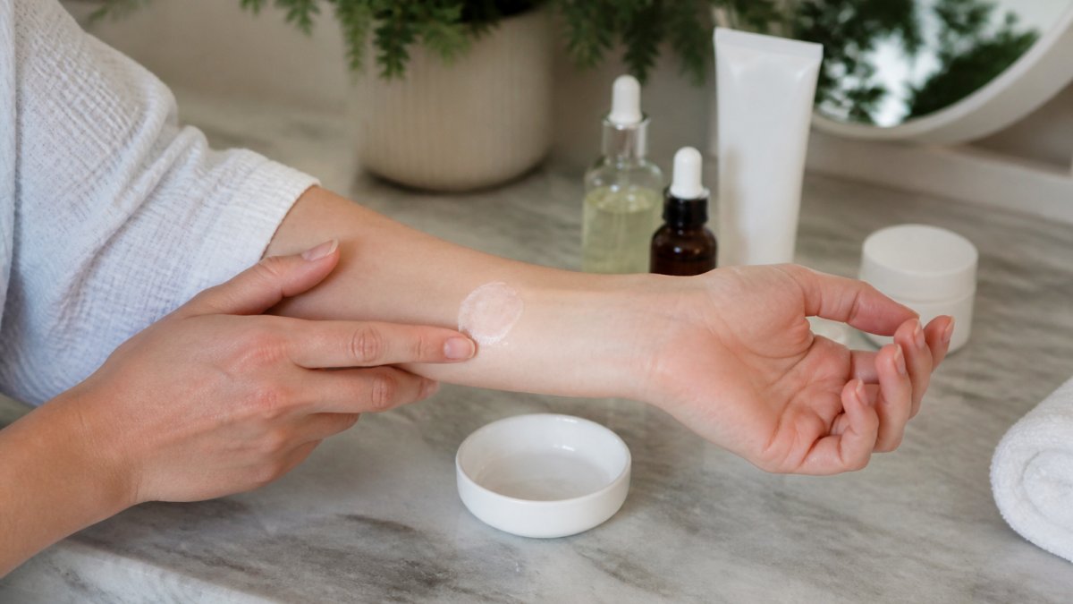 Close-up of a person's inner forearm with a small patch of skincare product applied, soft natural lighting, clean bathroom setting