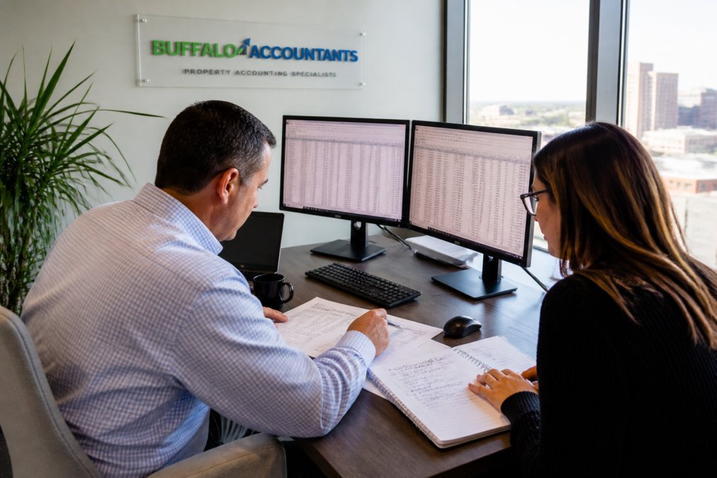 Controller and accountant reviewing financial statements for property data integration in a modern office
