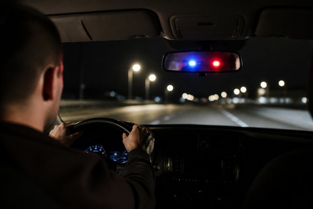 Driver with hands on the steering wheel during a police traffic stop that could lead to a first offense OWI.