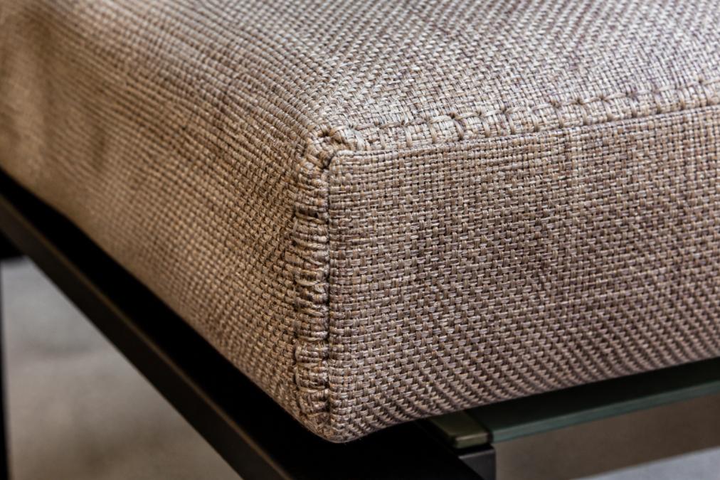 Close-up of densely woven commercial upholstery fabric showing tight stitching, reinforced seams, and heavy-duty thread on a structured frame