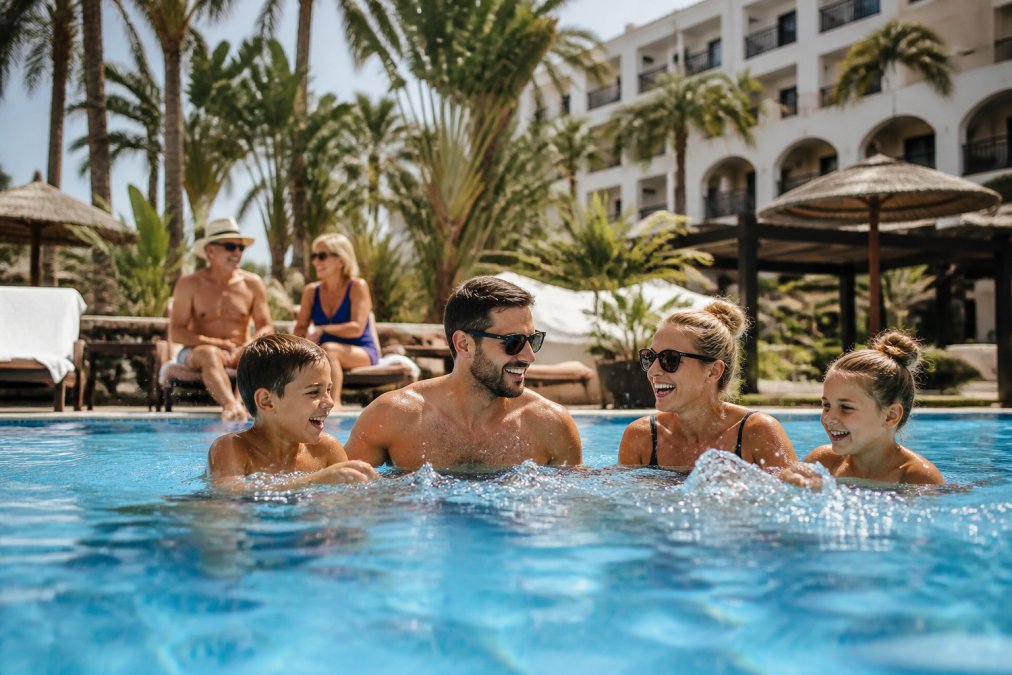 Familie genietend van het zwembad en faciliteiten van een all-inclusive resort, met verschillende leeftijdsgroepen die ontspannen en plezier hebben