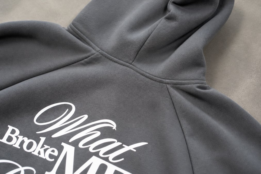 Close-up of premium heavyweight hoodie showing detailed stitching, seams, and fabric weave with natural lighting highlighting the craftsmanship and thread consistency