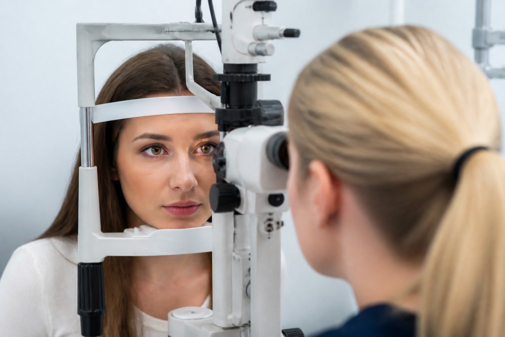Close-up of patient undergoing eye examination with advanced diagnostic equipment visible during consultation, with patient looking directly ahead during assessment in modern clinical setting