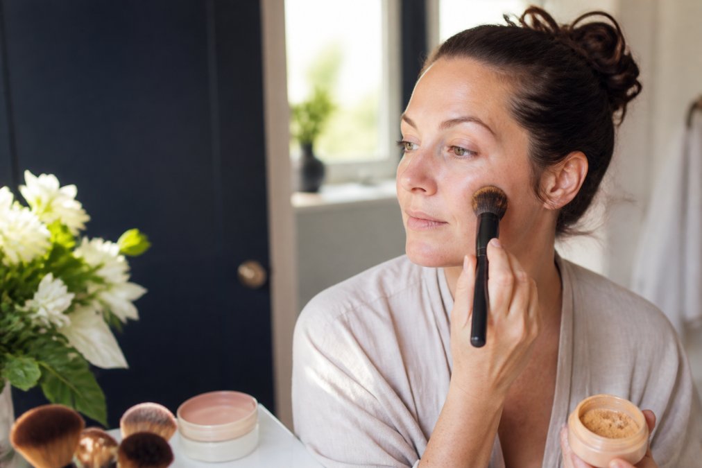 Step-by-step guide showing the gentle application of mineral powder foundation using a cosmetic brush