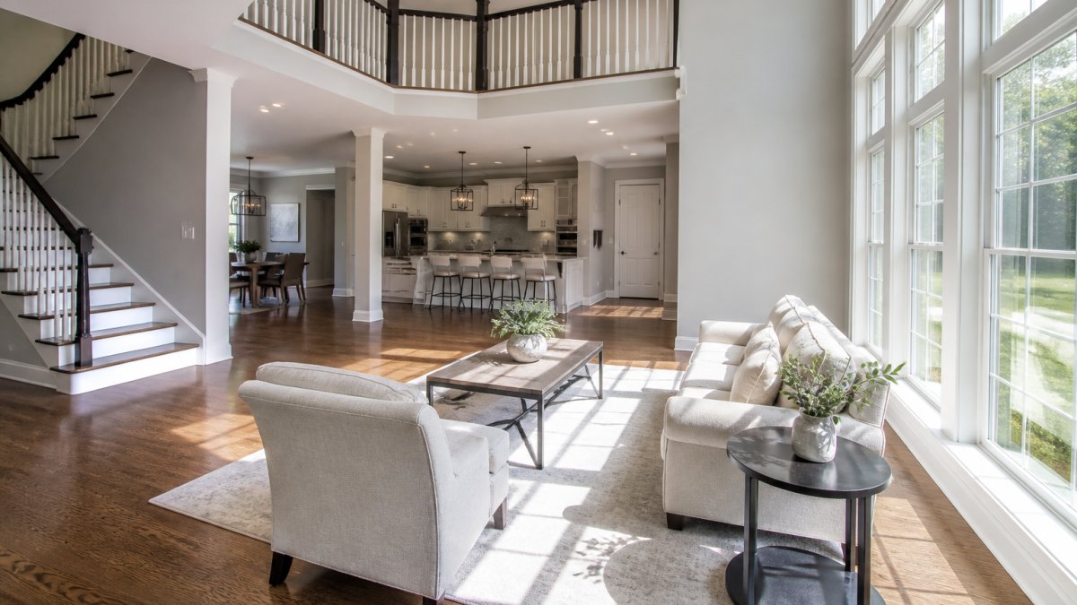 Spacious, bright living room with minimal furniture, clear sightlines showing open floor plan, and neutral décor that appeals to buyers, natural sunlight streaming through large windows