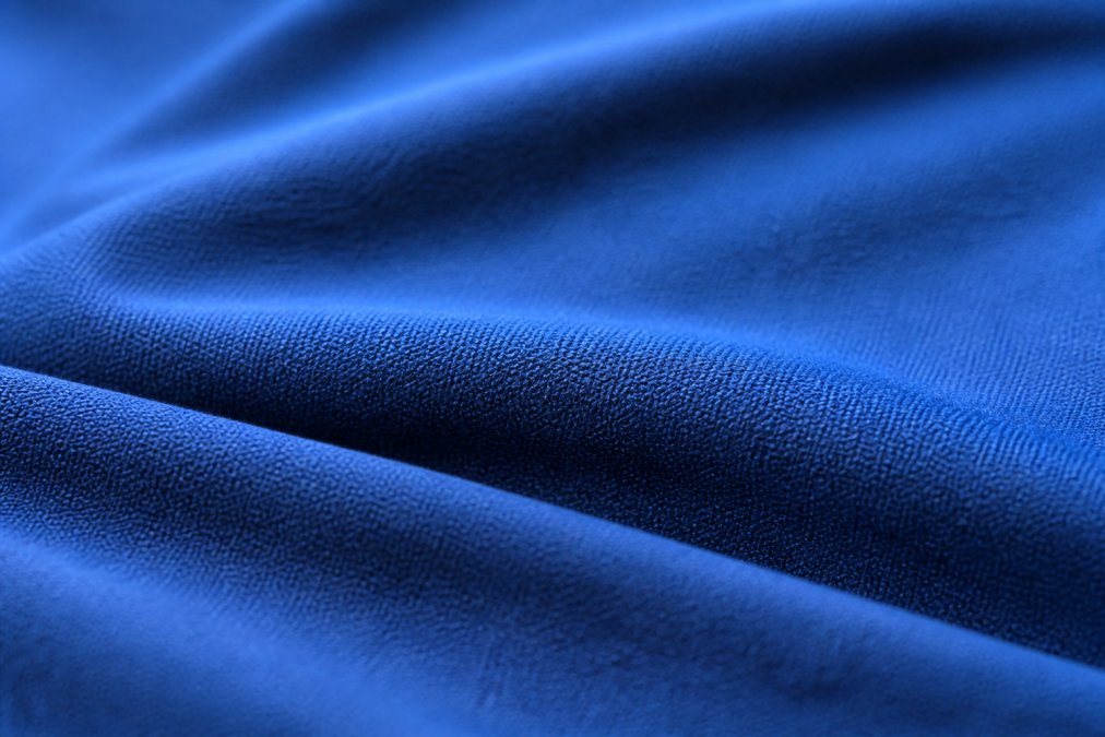Close-up of premium fabric texture showing tight, even weave with vibrant color saturation and refined finish under natural side lighting