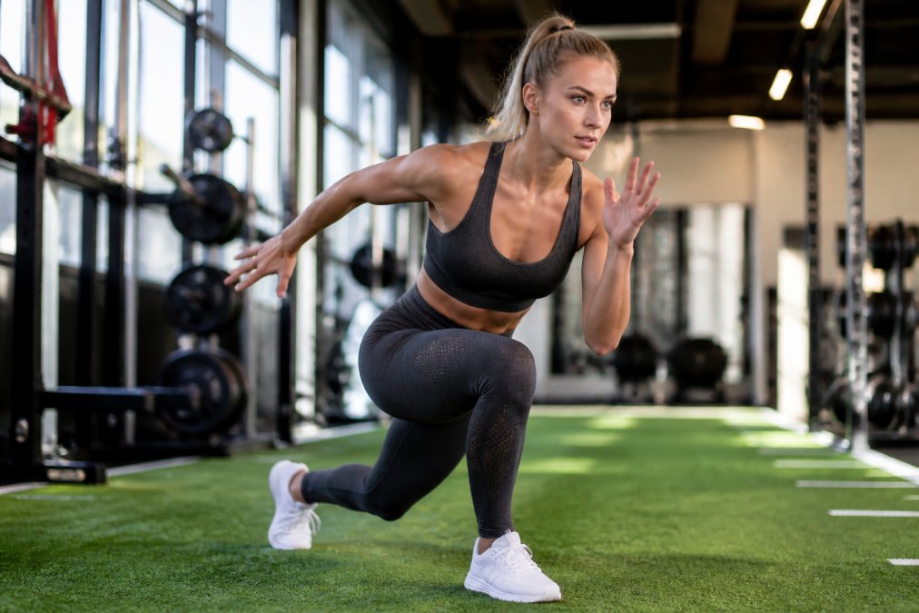 Athlete performing high-intensity interval training in seamless activewear, showing dynamic movement and secure fit during intense exercise in modern gym setting with bright lighting