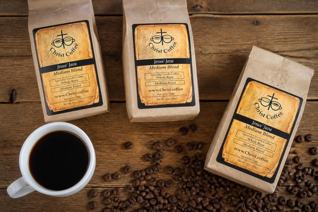 Overhead shot of specialty coffee bags with visible tasting notes, roast dates, and origin information arranged on a wooden surface next to a white ceramic cup filled with brewed coffee