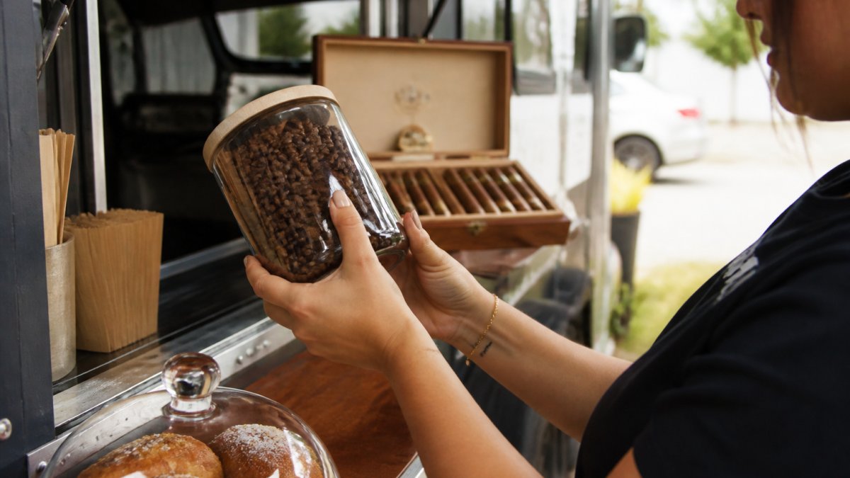 Freshly roasted specialty coffee beans in a glass jar with a roast date label to show if is specialty coffee worth the