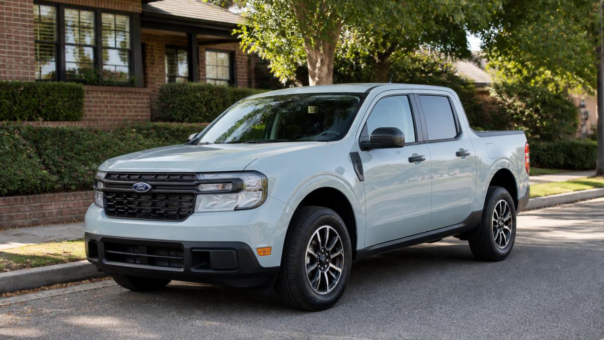 A 2026 Ford Maverick Hybrid parked in natural daylight, showing the truck's compact size and modern design from a three-quarter front angle on a residential street