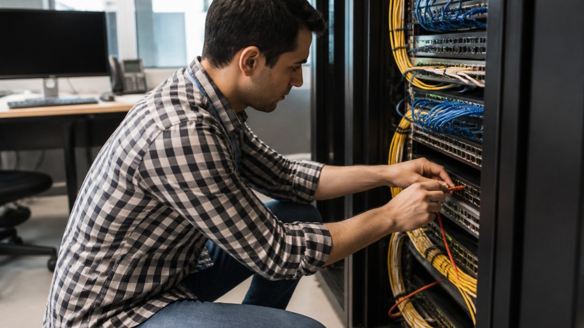 IT professional troubleshooting network security dashboards to determine zero trust security worth in a modern office