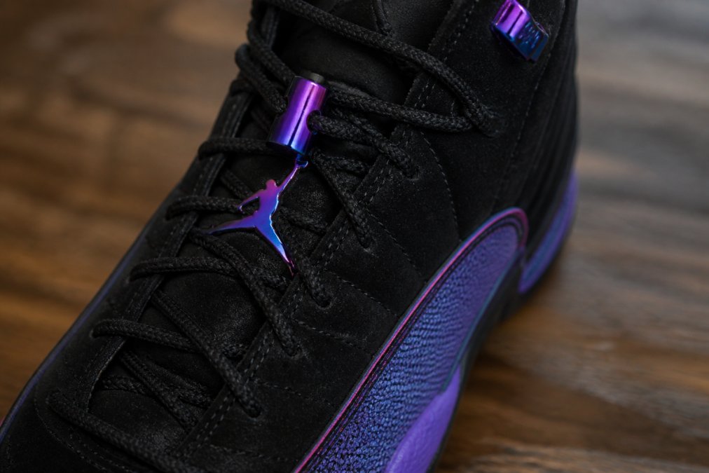 Close-up of the black nubuck upper with hyper violet and pink blast accents, showing iridescent details and the signature lace lock system in natural studio lighting
