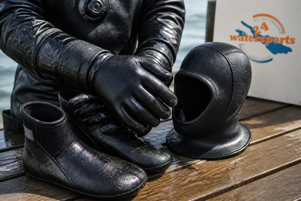 Dicke Neopren-Handschuhe und Kopfhaube als Teil der Kaltwasser-Tauchausrüstung Tipps mit Wassertropfen.