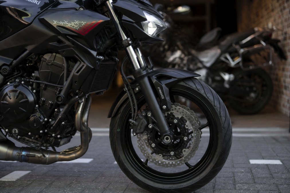 Close-up van voorkant Kawasaki Z650 met nadruk op vering, remschijven en LED-koplampen, scherpgesteld op technische details