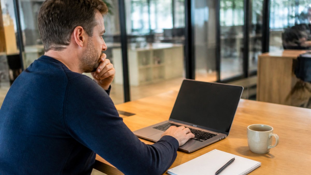Ondernemer werkt in een modern kantoor aan klantcontact automatiseren KMO via een chatbot op de computer.