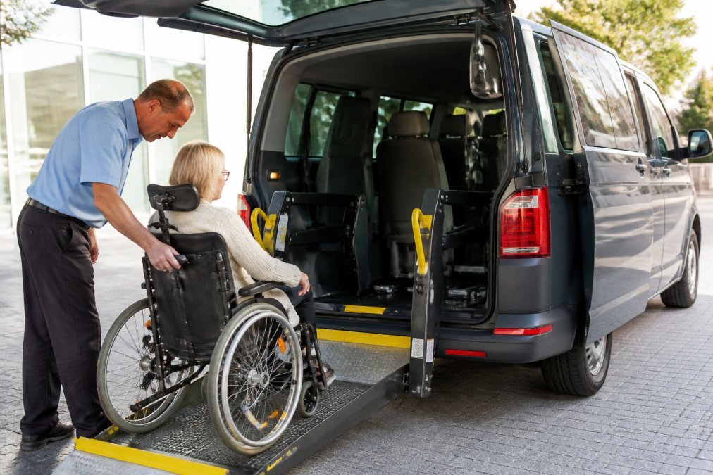 Ervaren chauffeur helpt rolstoelgebruiker bij instappen in aangepast vervoer voor kosten rolstoelvervoer dialyse