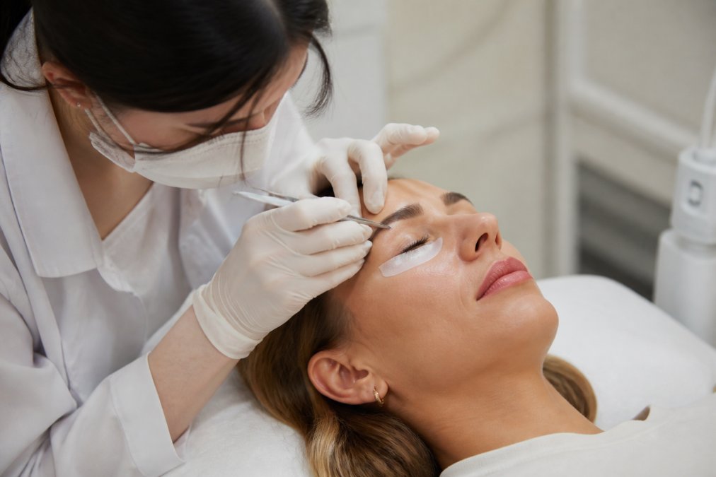 Lash artist applying hypoallergenic extensions to a client to compare lash lifts vs extensions in a calm salon