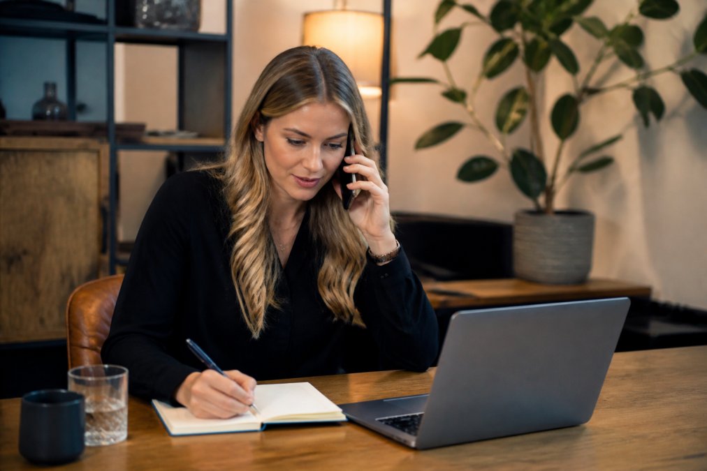 Eventorganisator regelt last minute live entertainment voor evenement via laptop en telefoon aan een bureau
