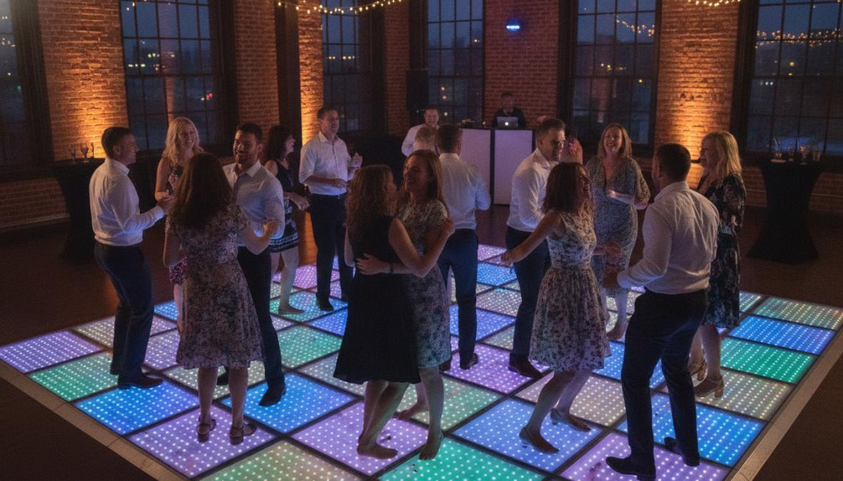 Groep feestgangers dansend op een fel verlichte LED dansvloer met kleurrijke lichteffecten, vrolijke gezichten en dynamische bewegingen in een feestzaal